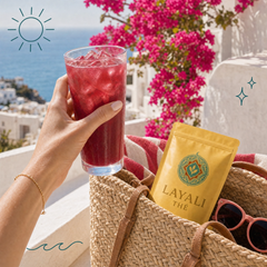 Iced hibiscusdrank van Layali Thé op een zonnig terras aan zee